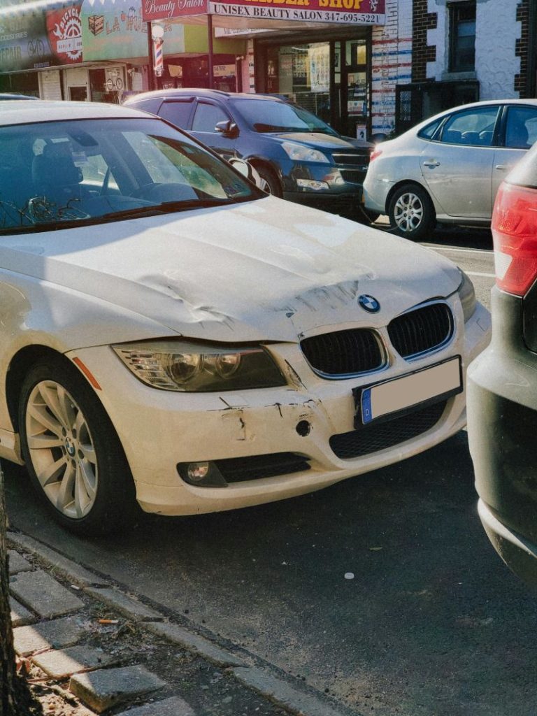 Damaged white BMW car parked